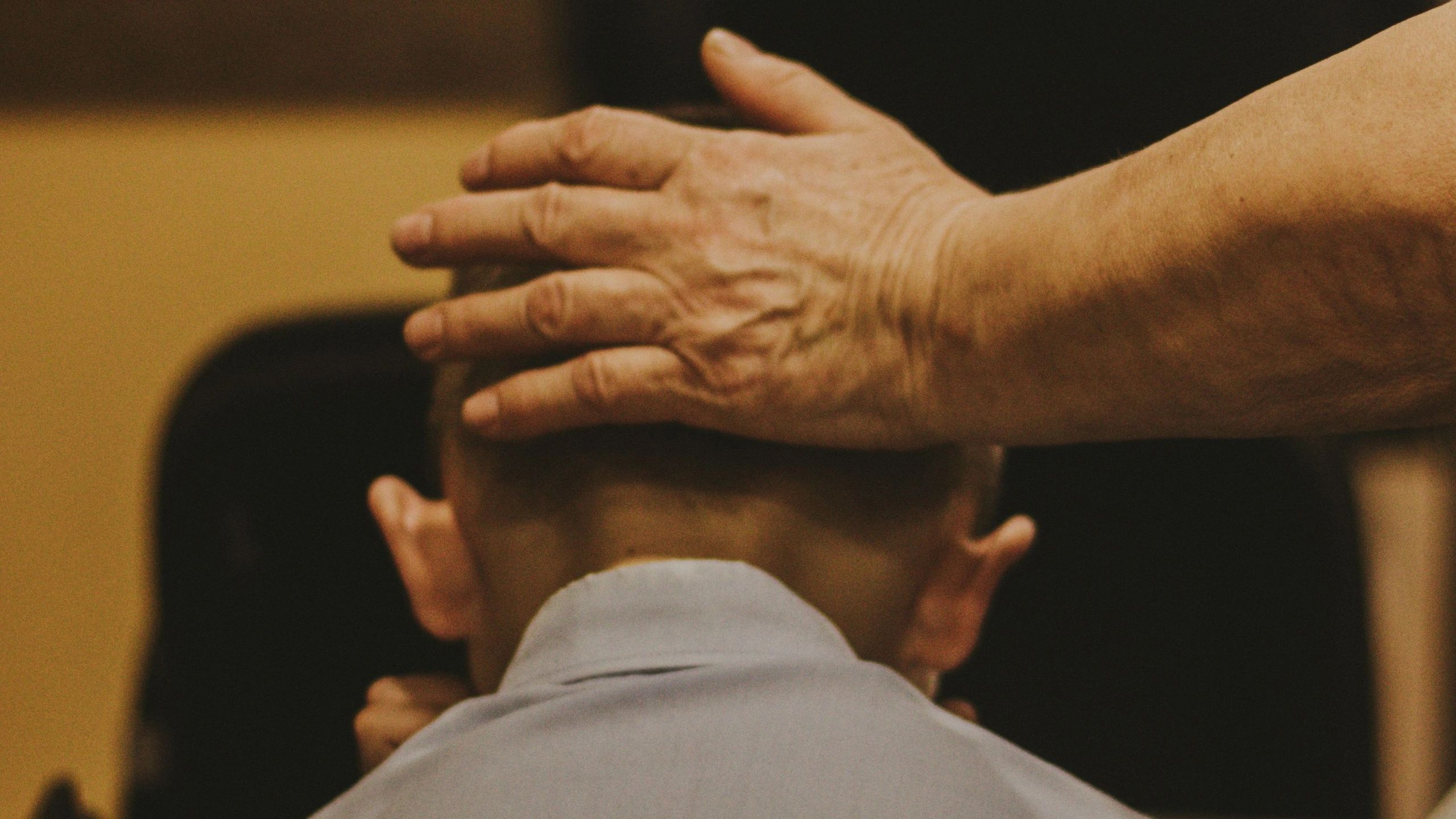 Man placing hand on boy's head