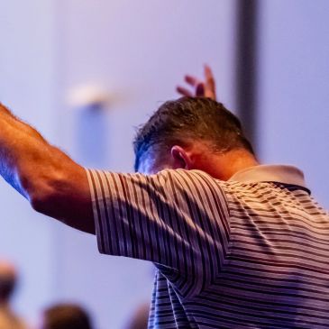 Man raising arms, possibly in worship or celebration.