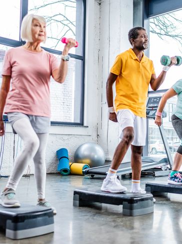 Two senior friends exercising in a gym