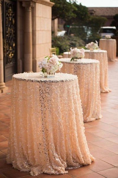 Elegant cocktail tables with floral tablecloths and rose centerpieces.
