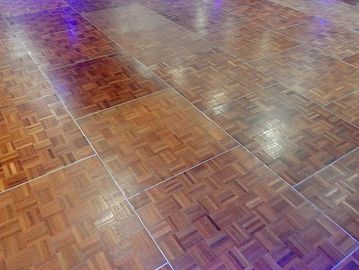 Shiny wooden parquet flooring with a checkered pattern.
