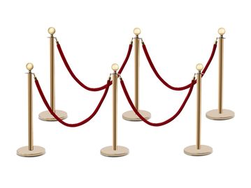 Set of gold stanchions with red velvet ropes forming a barrier.