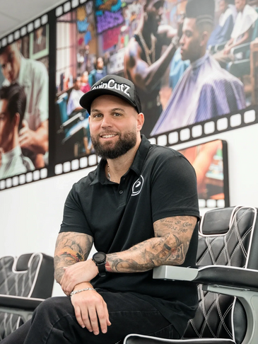 Sean Casey founder sitting in barber chair inside barber academy.