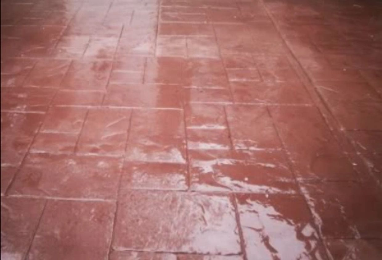 Wet red tiled floor reflecting light.