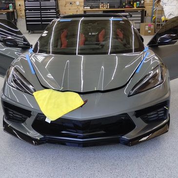 A gray sports car with yellow hood and front end.