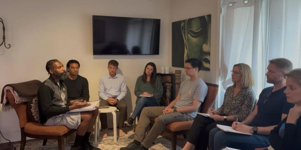 Group therapy session with participants seated in a circle sharing thoughts.
