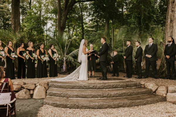Outdoor wedding ceremony with bride and groom exchanging vows.