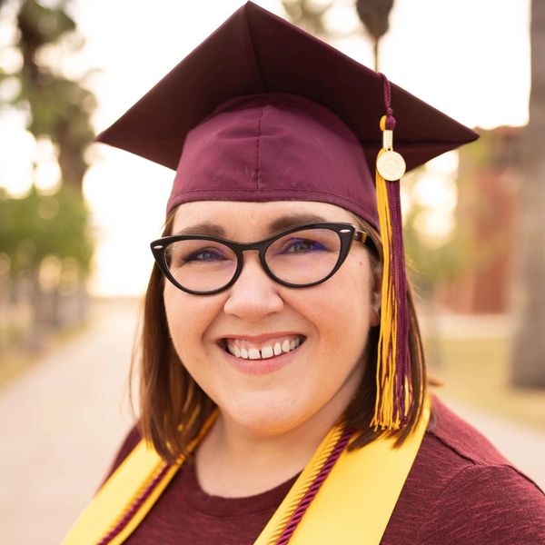 Professional photo of smiling woman wearing Arizona State University graduation cap & honor cords