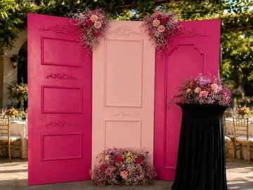 Decorative pink and peach panels adorned with flowers at an outdoor event.