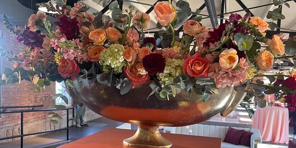 Elegant floral centerpiece with orange and pink flowers.