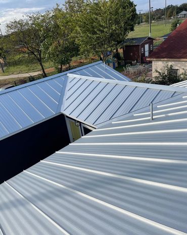 Metal roofs of various shapes and angles under daylight.