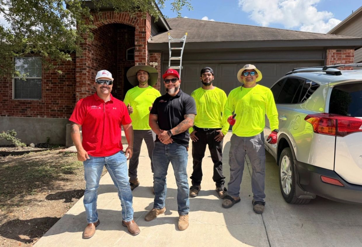 Group of five men standing outside a house on a sunny day.