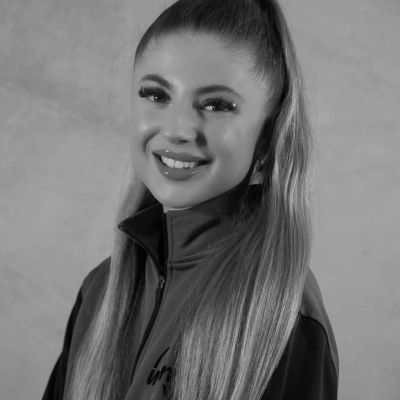 Smiling woman with long straight hair in a high ponytail.