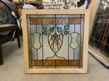 Stained and textured glass window with urn and plant motif.