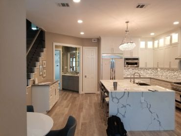 Modern kitchen with marble island and stainless steel appliances.