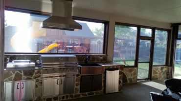 Indoor kitchen with large windows and stone decor.