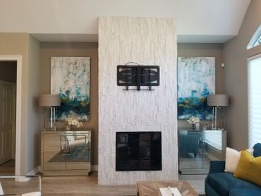 Modern living room with a sleek fireplace and mirrored side tables.