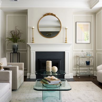 Elegant living room with classic fireplace and glass coffee tables.