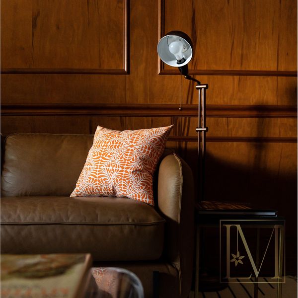 brown leather couch with modern floor lamp