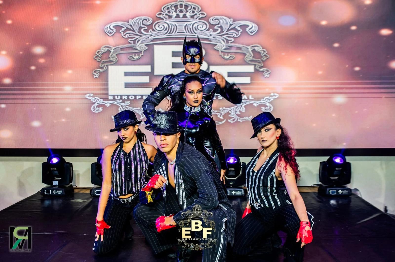 Dancers in striking costumes pose at the Europe Bachata Festival stage.