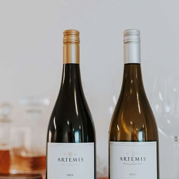 Two Artemis wine bottles with gold and silver caps.
