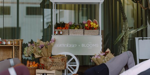 A fresh fruit and flower cart with baskets and bouquets on display.