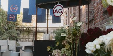Outdoor cafe area with AG branded decor and floral arrangements.