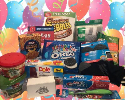 A festive assortment of snacks and personal care items against a colorful balloon backdrop.