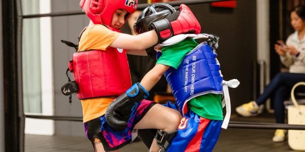 Two kids sparring in martial arts gear.