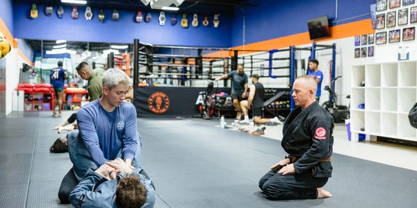 Atlas Muay Thai students training together on the mats.