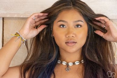Headshot of a beautiful young woman with long brown hair, brown eyes and olive complexion.