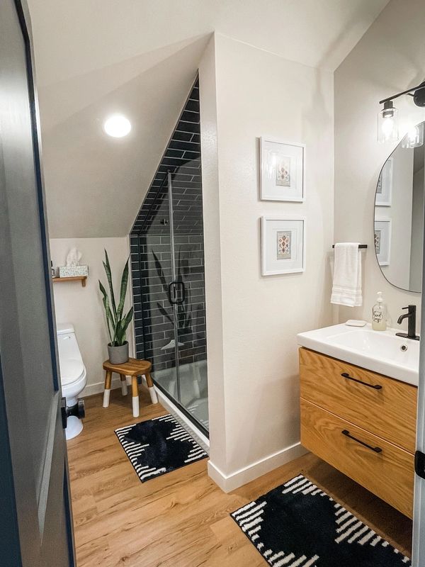 Modern bathroom with wooden flooring and black accents.