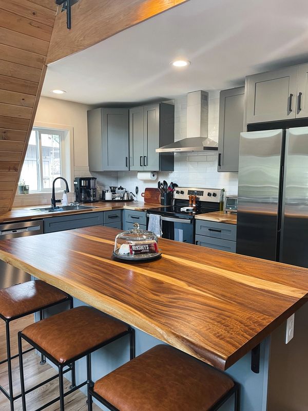 Modern kitchen with wooden countertop and stools.