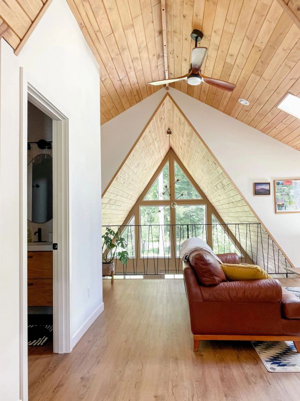 View from the upstairs queen bedroom shows the secondary living space with a bathroom to the left.