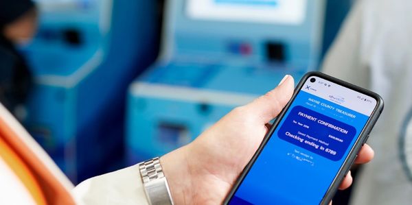 Person holding phone displaying currency conversion app.