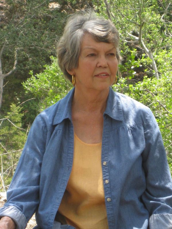 Older woman outdoors wearing blue shirt and yellow top.