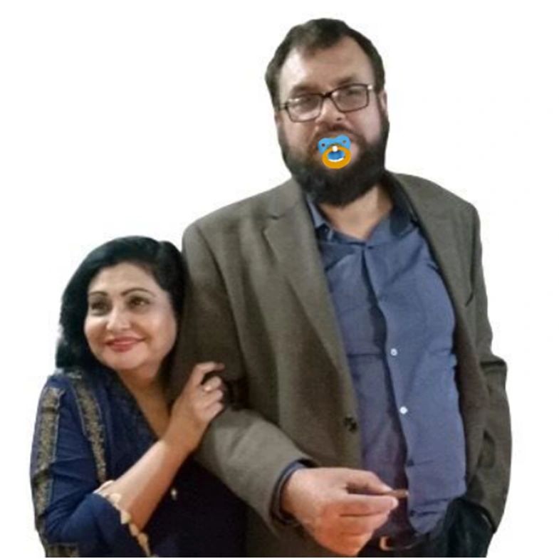 A woman affectionately holds a man's arm with a pacifier edited on his mouth.