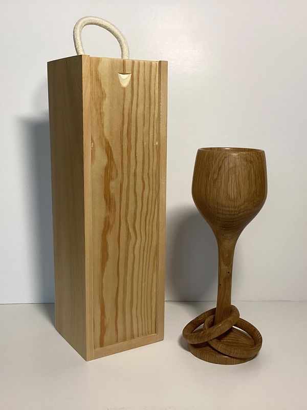 A wooden wine box holder with a wooden tall glass
