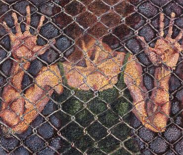 A person pressing their hands against a chain-link fence.