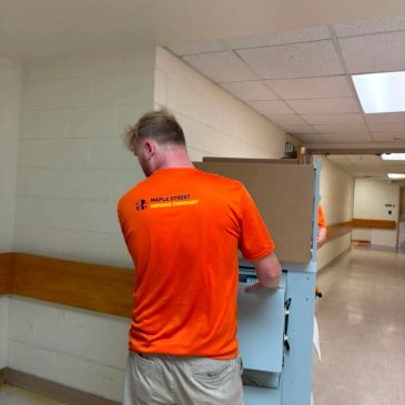 Mover transporting a large object in a hallway.