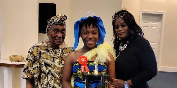 Three generations celebrating a young girl's achievement with a trophy and smiles.