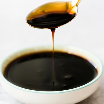 spoon dripping dark brown molasses.