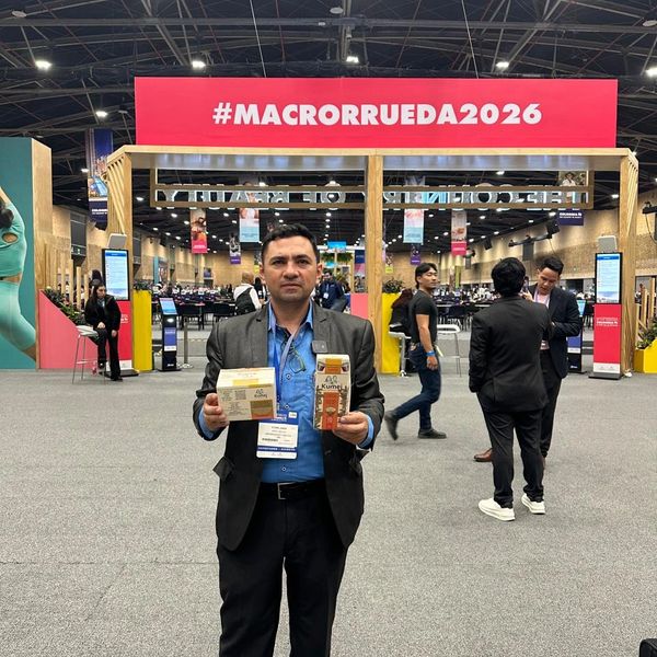 Man holding products at #MACRORRUEDA2026 event in a large exhibition hall.