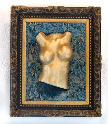 Sculpted female torso framed with ornate borders and blue patterned background.