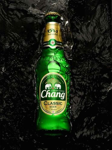 Hand holding a camera while capturing a liquor bottle image for marketing