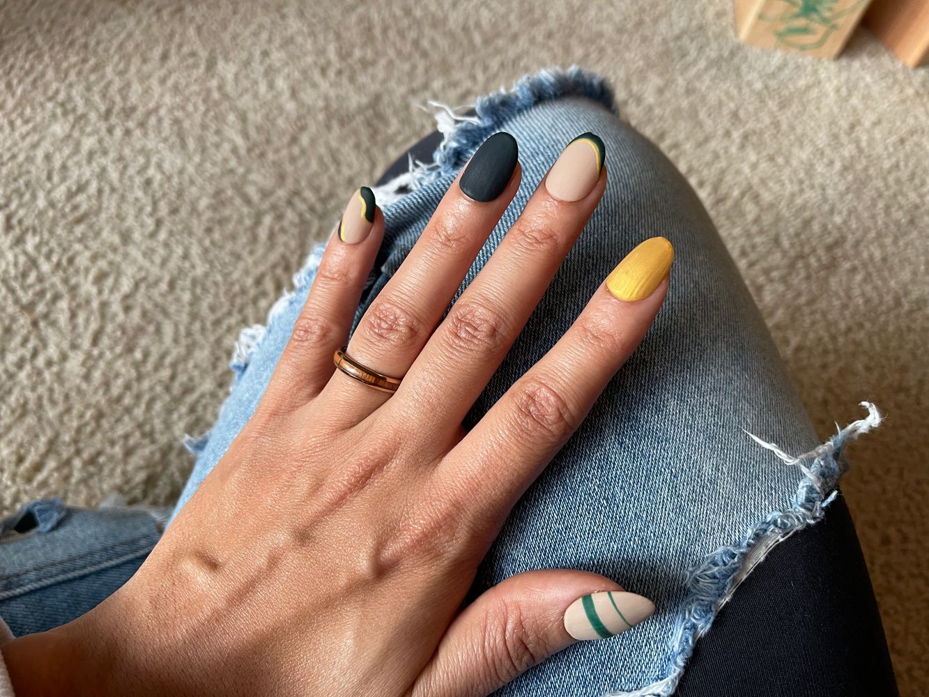 Hand of an black woman show casing her short oval luxury press on nails with abstract design.