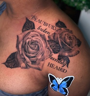 Black and gray rose tattoo with the words "Beautifully broken humbly healed" on a shoulder.