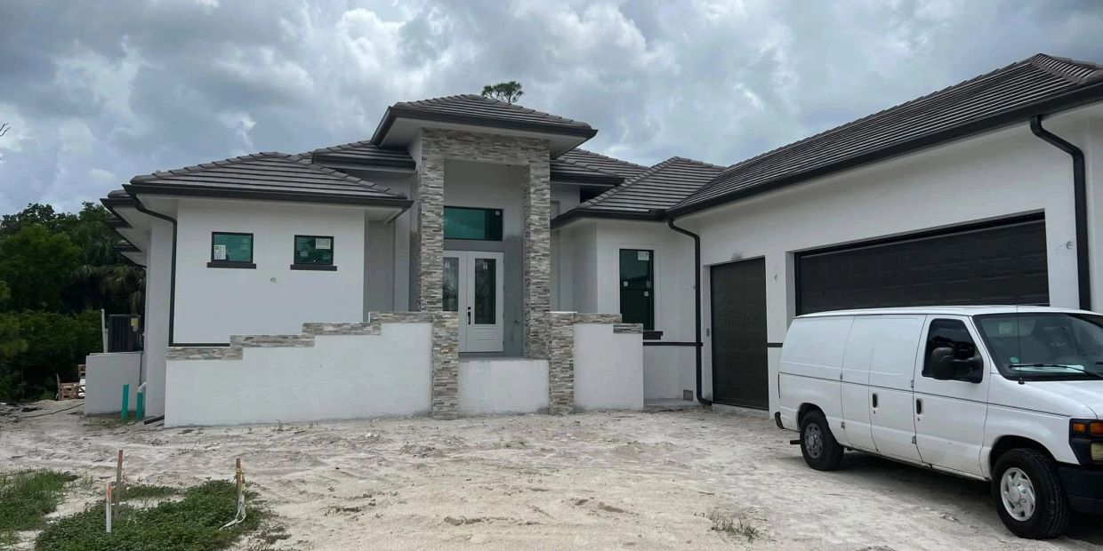 Newly built modern house with a white van parked outside.