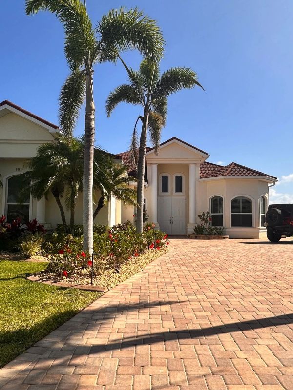 Sunny day at a Mediterranean-style house with palm trees.