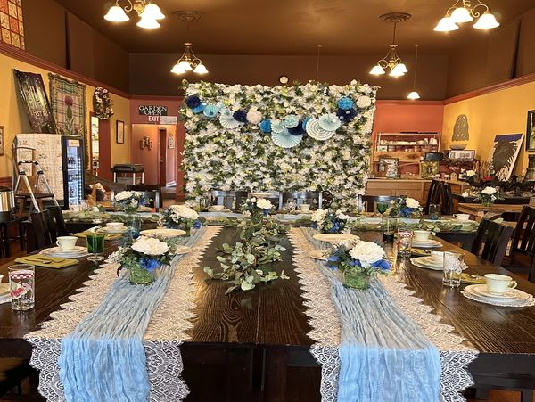Elegant dining table setup with floral decorations and blue accents.